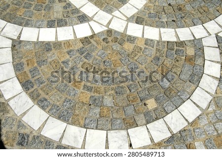 An ancient granite pavement, a path made of old cobblestones, background. A road in a European city.