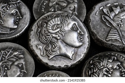 Ancient Greek coins close-up, portrait of Alexander the Great in center, silver tetradrachm coins. Concept of old rare money, valuable coins collection, history of Hellenistic Greece and numismatics.