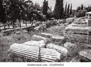 Ancient Greek Ruins At Acropolis Foot, Athens, Greece, Europe. Scenic View Of Historical Athens City, Remains Of Old Fallen Buildings And Temples. Concept Of Past Civilization, Black And White Photo.