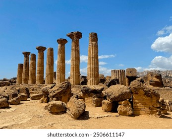 Ancient Greek Temple of Herakles ruins with Doric columns amid boulders under a blue sky in Agrigento’s Valley of the Temples, Sicily. Captures historical grandeur and natural beauty - Powered by Shutterstock