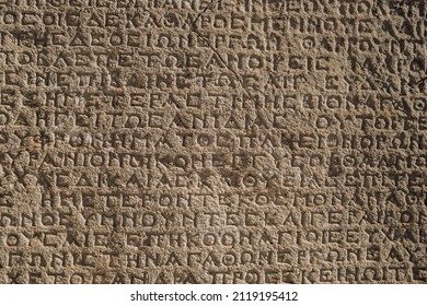 Ancient greek writings on a rock. Historic Arsameia ruins in Eastern Turkey. Ancient greek inscriptions on the wall of archeological ruins close-up. Archeological concept background