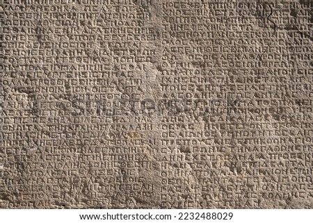 Ancient greek writings on a rock. Historic Arsameia ruins in Eastern Turkey. Ancient greek inscriptions on the wall of archeological ruins close-up. Archeological concept background