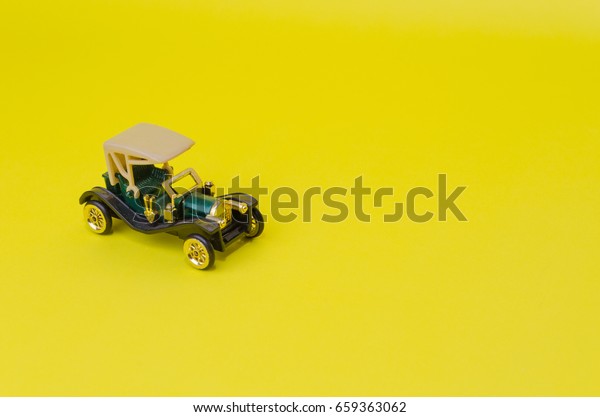 ancient green convertible\
classic car, old toy car on yellow background, selective focus,\
copy space