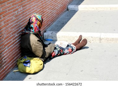 Ancient Gypsy With Lurid Clothes While Begging On The Street