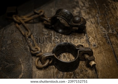 Ancient iron handcuffs used in medieval times as wrist restraints for castle dungeon prisoners. Photographed at Westgate Towers Museum in Canterbury, England.