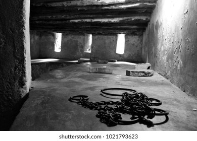 Ancient iron shackles, used to chain slaves, lie on the cold concrete of a dungeon at the old slave-trading port of Stone Town, Zanzibar.
