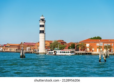 The ancient lighthouse of the island of Murano, famous for the production of artistic glass, with the Vaporetto station (ferry) called Murano Punta Faro, Venice Lagoon, Venice, Veneto, Italy, Europe.