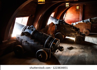 Ancient Military Galleon Ship With Round Shot Cannons. Iron Cannon Gun Inside Vintage Spanish Wooden Watercraft. Tourist Attraction In Dock. Old Vessel Boat With Antique Artillery Weapons