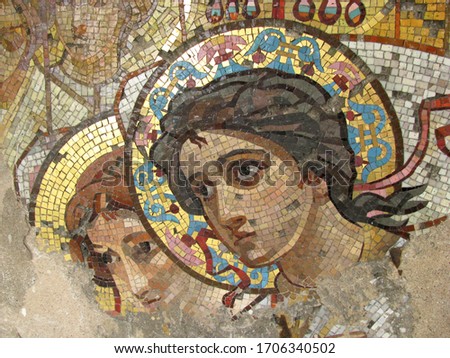 Ancient mosaic on the wall of the temple with the image of angels with golden crowns