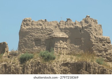 Ancient mud brick structure on a hilltop with clear blue sky