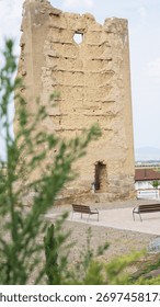 Ancient mud brick tower with a window, part of historical ruins in a rural landscape, Araciel Tower