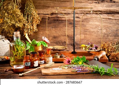 Ancient natural medicine, herbs, vials and old apothecary scales on wooden background