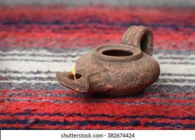 Ancient Oil Lamp From Israel Over Colorful Textile