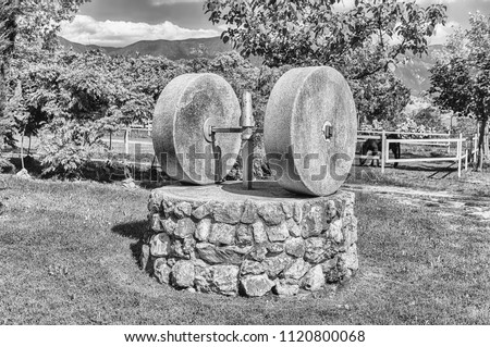 Ancient olive press with two millstones in the countryside