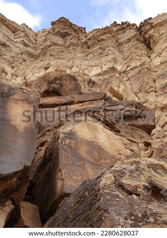 ancient petroplyphs of the native american fremont culture on a boulder  next to a steep cliff in nine mile canyon, near wellington, utah