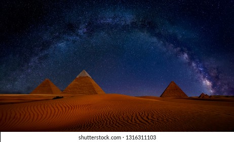 Ancient Pyramids of Giza at night against the stars and Milky Way Galaxy, Egypt. Astrophotography, fantastic background, beautiful dunes in desert, panoramic view