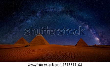 Ancient Pyramids of Giza at night against the stars and Milky Way Galaxy, Egypt. Astrophotography, fantastic background, beautiful dunes in desert, panoramic view