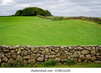 A Ancient Rock Wall And Beautiful Ireland Country Side Landscape View On An Overcast Cloudy Day.