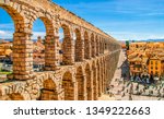 Ancient Roman aqueduct on Plaza del Azoguejo square and old building towns in Segovia, Spain.
