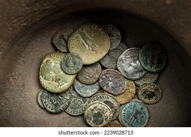 Ancient roman coins inside a ceramic jar.