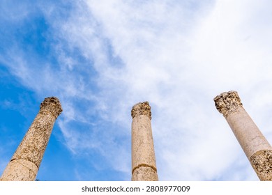 Ancient Roman columns against a dramatic blue sky in Jerash, Jordan