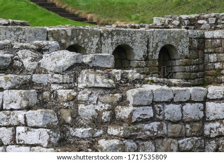 Ancient roman structures archways made of moss covered stones      