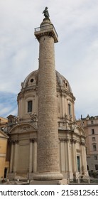 Ancient Roman Trajans Column
 With A High Relief And The Church Of The Most Holy Name Of Mary At The Trajan Forum With Dome