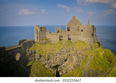  an ancient, ruined castle atop a cliff with greenery, overlooking the sea under a clear sky. - Powered by Shutterstock