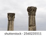 Ancient Ruins, Majestic Columns Against a Cloudy Sky. Stone columns reach for the sky, lost civilization, copy space, selective focus