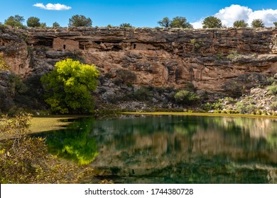 Ancient ruins and surroundings reflect on the quiet water of Montezuma Well. Part of Montezuma Castle National Monument in Arizona. - Powered by Shutterstock