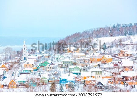Ancient russian town Ples with old wooden colorful houses on the Volga river in winter with snow. Ivanovo region, Russia.