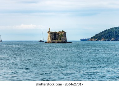 Ancient Scola Tower (Torre Scola) or of Saint John Baptist, XVII century, entrance the port of the Gulf of La Spezia, Porto Venere, Liguria, Italy, Europe. On the right the island of Palmaria.