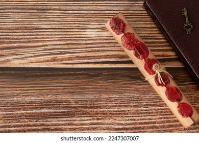 Ancient scroll with seven seals and antique key with closed holy bible book on wooden table. Copy space, top view. Christian prophecy, apocalypse, revelation of God Jesus Christ, biblical concept. - Shutterstock ID 2247307007