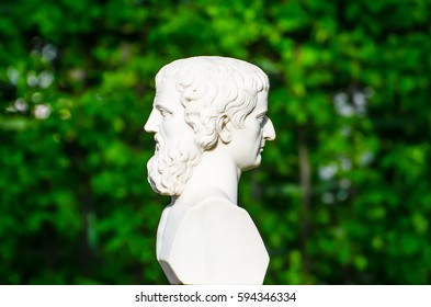 Ancient sculpture head on both sides conceptually profile of a human face in the park