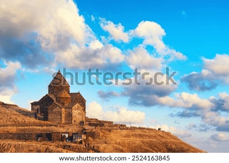 Ancient Sevanavank monastery on Lake Sevan in Armenia against blue colorful sky with clouds.