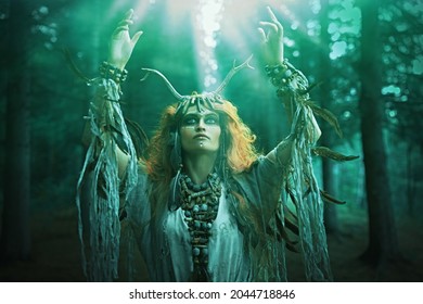 An Ancient Shaman Woman In Ritual Garment Performs A Traditional Mystical Shamanic Ritual In The Forest. Fairy Forest Witch. Fantasy. Halloween. 