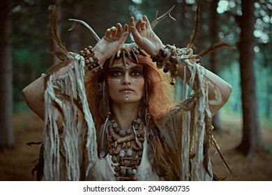 An Ancient Shaman Woman In Ritual Garment Performs A Traditional Mystical Shamanic Ritual In The Forest. Fairy Forest Witch. Fantasy. Halloween. 