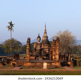 Ancient sitting Buddha statue and pagoda. Old buddhist temple. Sukhothai Historical Park. Thailand.