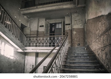 An ancient staircase in an old abandoned manor. Shabby and dirty walls. Beautiful architecture of an old abandoned building.