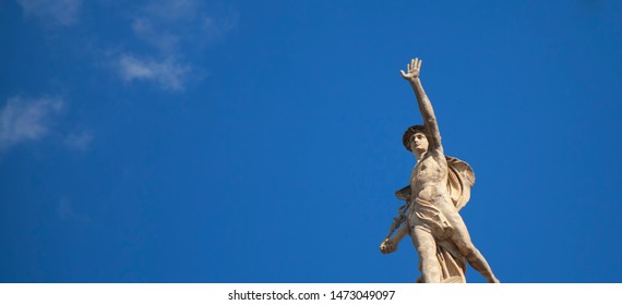 Ancient statue of the antique god of commerce, merchants and travelers Hermes (Mercury) against blue sky. He is alsow olympic gods messenger with wings on a helmet. 