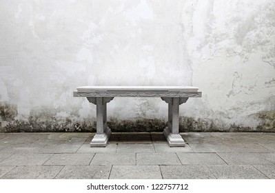 An Ancient Stone Altar Table Against A Grungy Stained Masonry Wall.