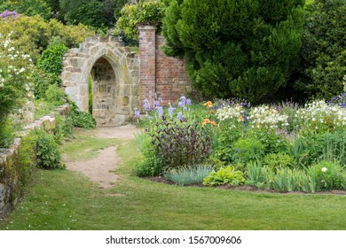 An Ancient Stone Arch In A Formal Garden In Kent, England