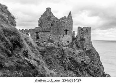 ancient stone castle ruins on a rugged cliff overlooking the ocean, under cloudy skies, showcasing a blend of history and dramatic coastal scenery - Powered by Shutterstock