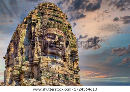Ancient stone faces at sunset of Bayon temple, Angkor Wat, Siam Reap, Cambodia