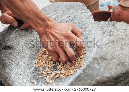 Ancient stone grinding tool with upper and lower stones, used for milling grains