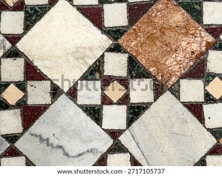 Ancient stone and marble mosaic pattern featuring square and rhomboid tiles