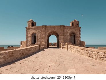 Ancient stone Mogador fort, Skala de la Kasbah, arch entrance at Essaouira coastal UNESCO landmark, the ramparts on the seafront in summer, ocean in background Morocco, - Powered by Shutterstock