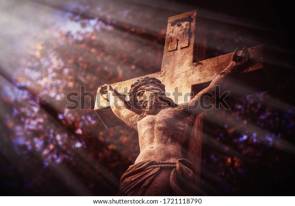 Ancient stone\
statue of the crucifixion of Jesus Christ in the sun\'s rays. Faith,\
religion, suffering, God\
concept.