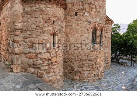 Ancient stone wall with arched windows in historic medieval building exterior.