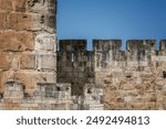 Ancient Stone Wall of Jerusalem Old City Against a Clear Blue Sky.